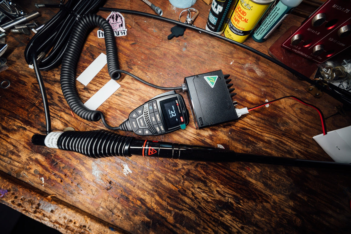 GME XRS Connect GMRS radio, handset and antenna laid out on a wooden workbench