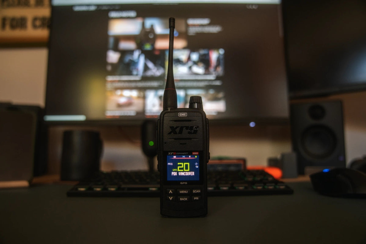 GME XRS-660-U standing on a desk in front of a monitor, its screen on GMRS 20 in the PDX VANCOUVER zone