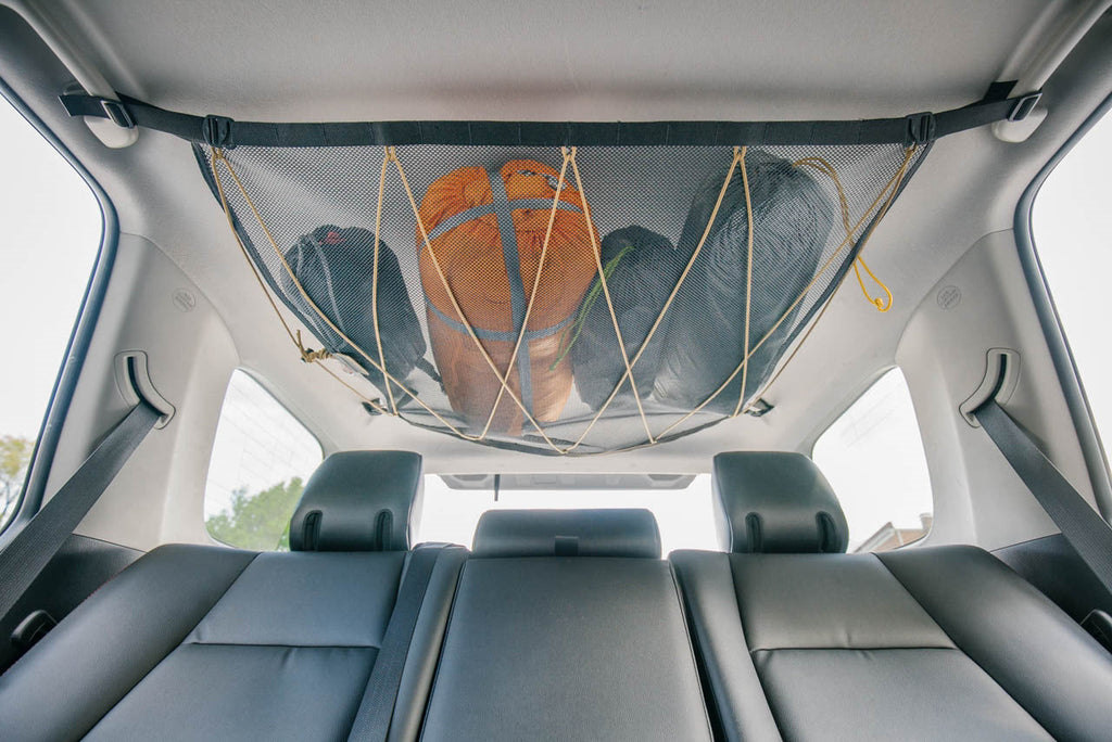 The attic fitted above the second row of a 4Runner, loaded with jackets and a helmet