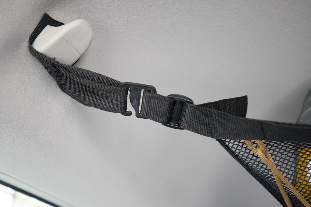 A G-hook and webbing strap clipped around a 4Runner grab handle