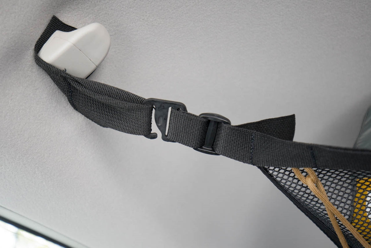 A G-hook and webbing strap clipped around a 4Runner grab handle