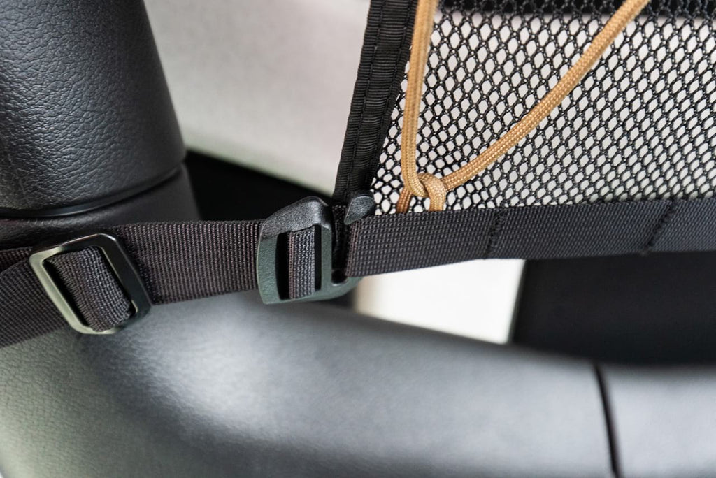 A webbing strap and buckle wrapped around the JLU roll bar
