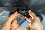 Threading the attic strap through the buckle on the mounting clip