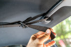 Pulling the attic strap tight at the grab handle