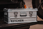 AluBox 42L aluminum case on a tailgate, front latches and handle, KITCHEN lettering on the side