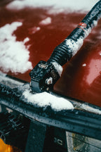 The fold-down bracket on the bull bar dusted with snow, antenna laid back