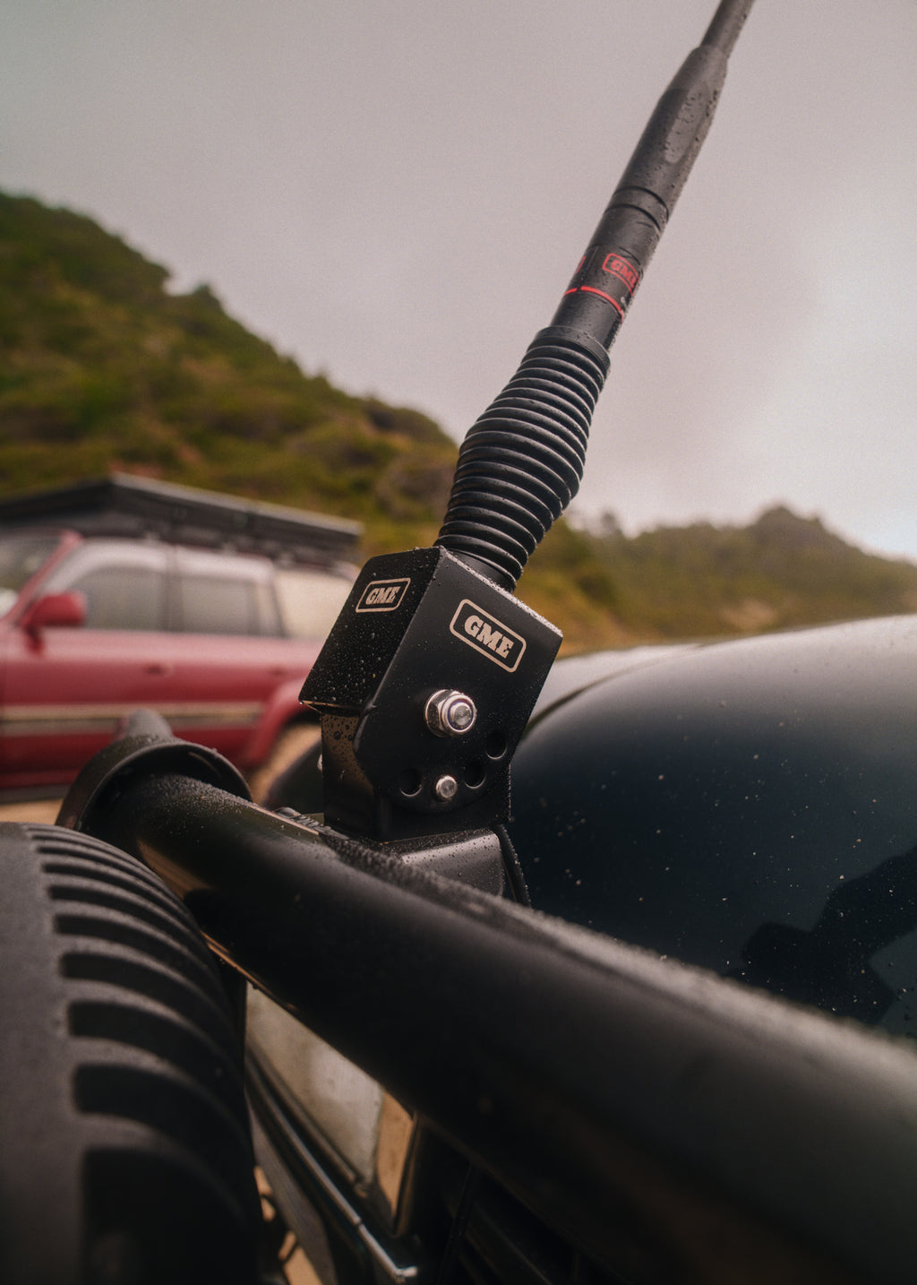 The fold-down bracket holding a GME antenna on our bull bar, hills behind