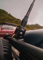 The fold-down bracket holding a GME antenna on our bull bar, hills behind