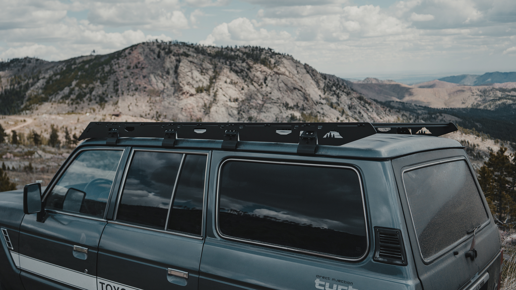 Mineral rack sideplate and gutter mounts along a 60 Series roof, granite peak behind