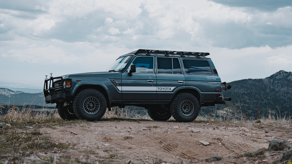 Gray 60 Series Land Cruiser with a Mineral roof rack parked on a mountain ridge