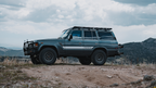 Gray 60 Series Land Cruiser with a Mineral roof rack parked on a mountain ridge