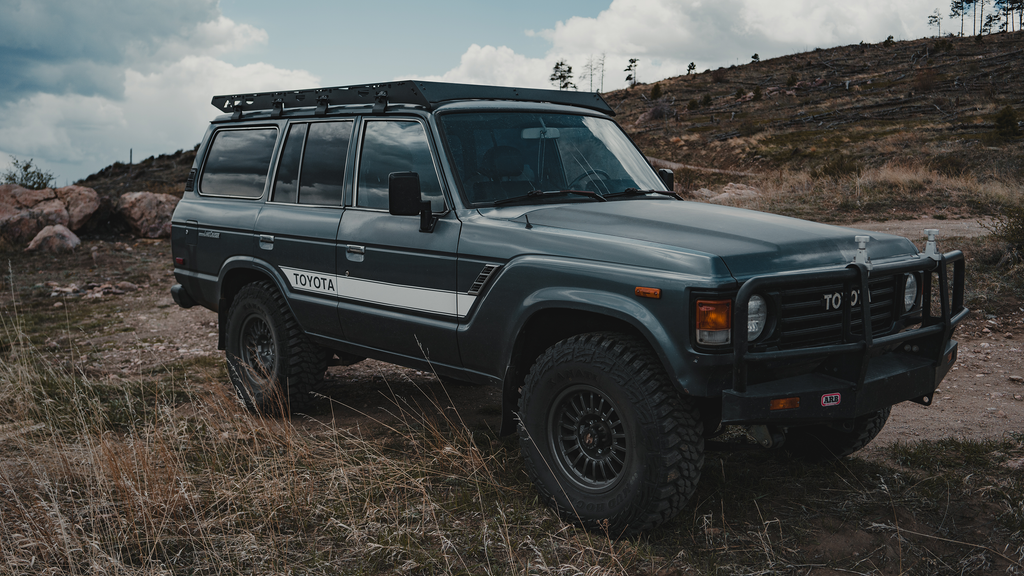 Gray 60 Series Land Cruiser with a Mineral rack and steel bumper on a dirt hilltop