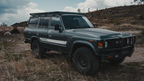 Gray 60 Series Land Cruiser with a Mineral rack and steel bumper on a dirt hilltop