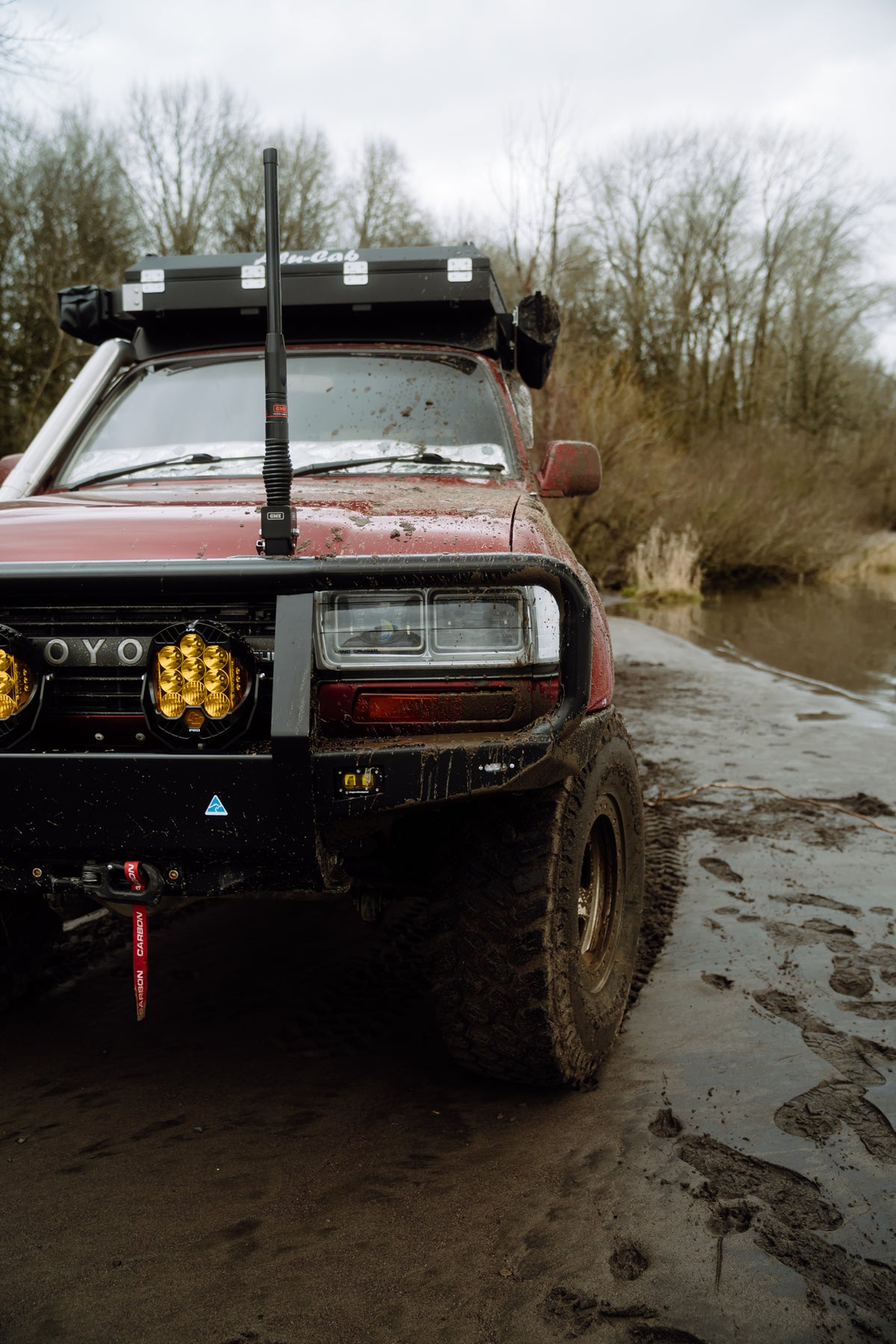 The GME antenna standing tall on the bull bar of our muddy 80 Series, amber driving lights below