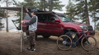 Awning deployed from Sherpa awning mounts on a red 4Runner at a lakeside camp