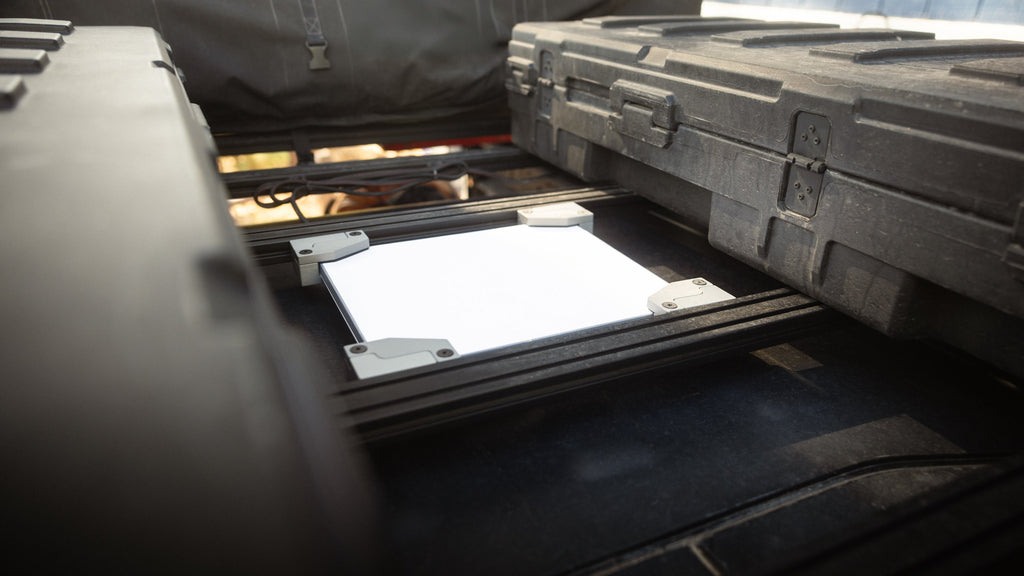 Starlink Mini held flush between Sherpa crossbars next to cargo cases