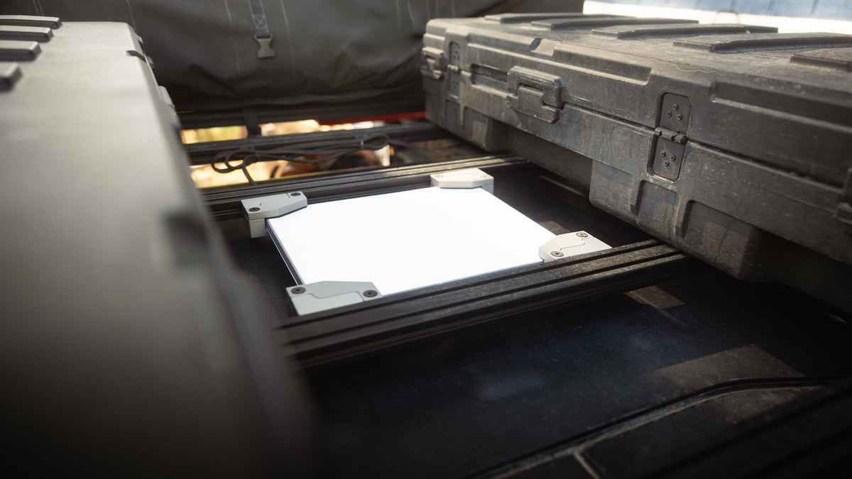 Starlink Mini held flush between Sherpa crossbars next to cargo cases