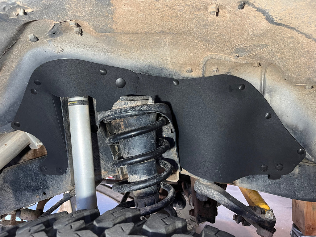 Ark rubber splash guard behind the coil spring and shock in a Land Cruiser HDJ80 wheel well