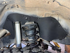 Ark rubber splash guard behind the coil spring and shock in a Land Cruiser HDJ80 wheel well