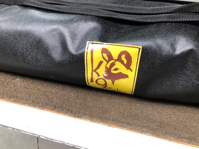 Eezi-Awn K9 Fold A Chair, close-up of the yellow K9 logo patch on the black carry bag