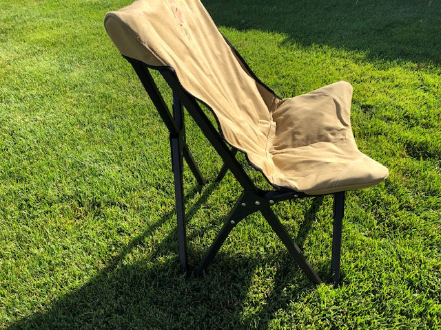 Eezi-Awn K9 Fold A Chair in Beige on grass, side view of the reclined back and black frame