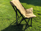 Eezi-Awn K9 Fold A Chair in Beige on grass, side view of the reclined back and black frame