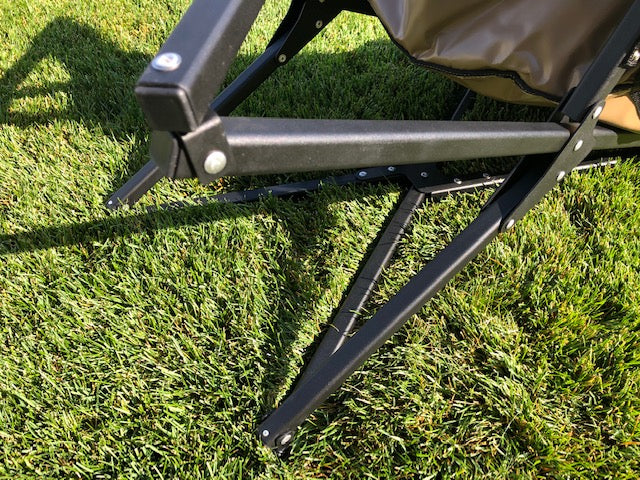 Eezi-Awn K9 Fold A Chair, close-up of the black frame joints and legs on grass