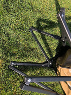 Eezi-Awn K9 Fold A Chair, black frame partly folded on grass, viewed from above