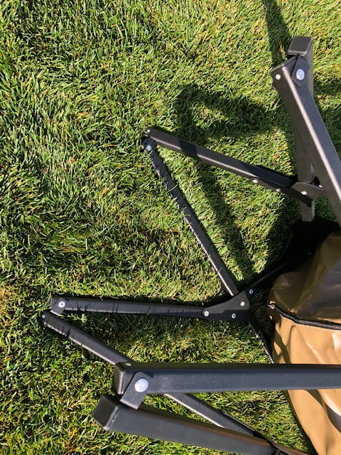 Eezi-Awn K9 Fold A Chair, black frame partly folded on grass, viewed from above
