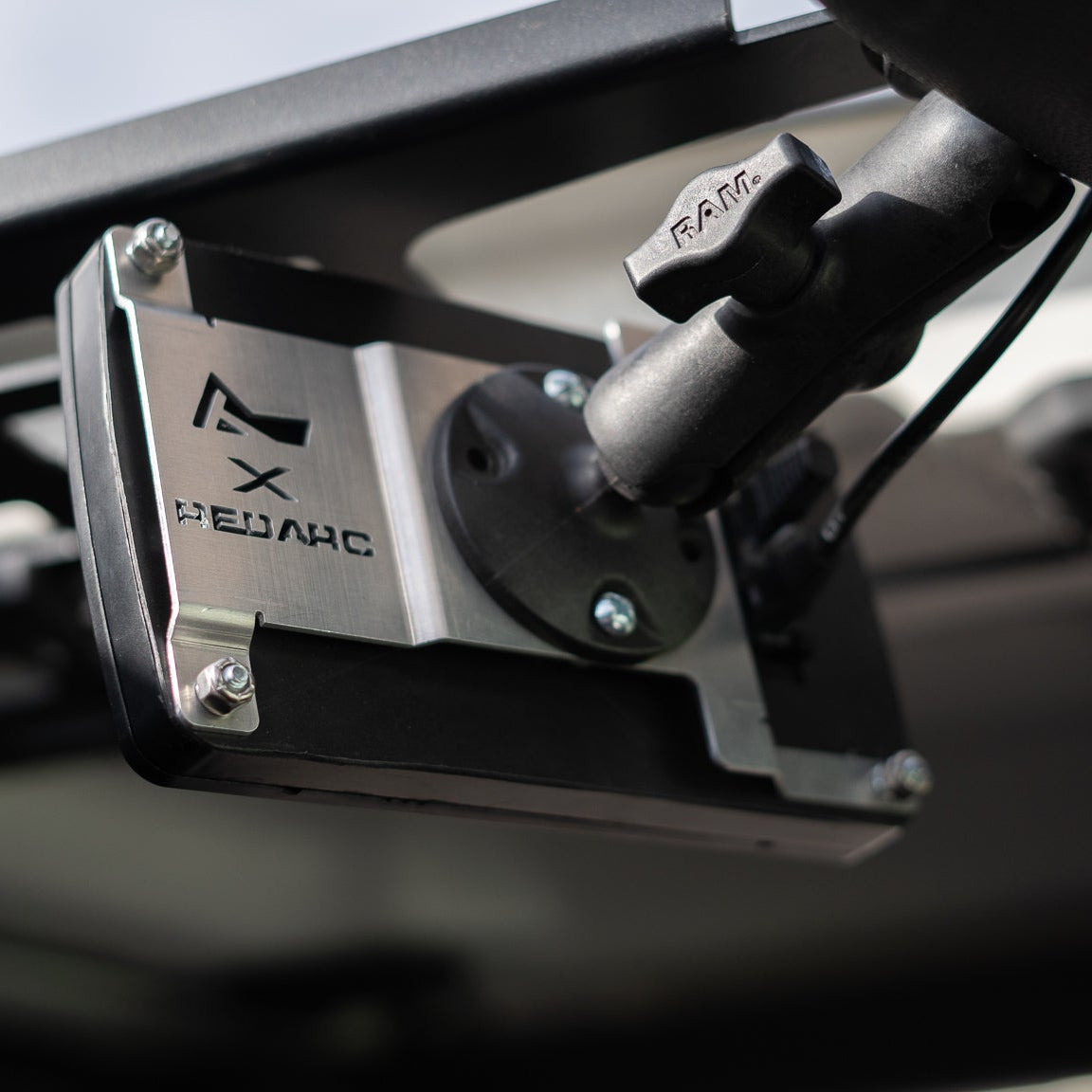 The bracket mounted to a headliner panel on a RAM ball arm, holding a RedVision display