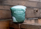 The Roo Double Printed packed into its attached stuff sack, sitting on a weathered wooden ledge