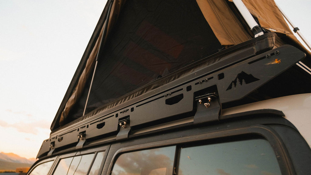 Sherpa La Sal sideplate and gutter mount under an open rooftop tent on an 80 Series