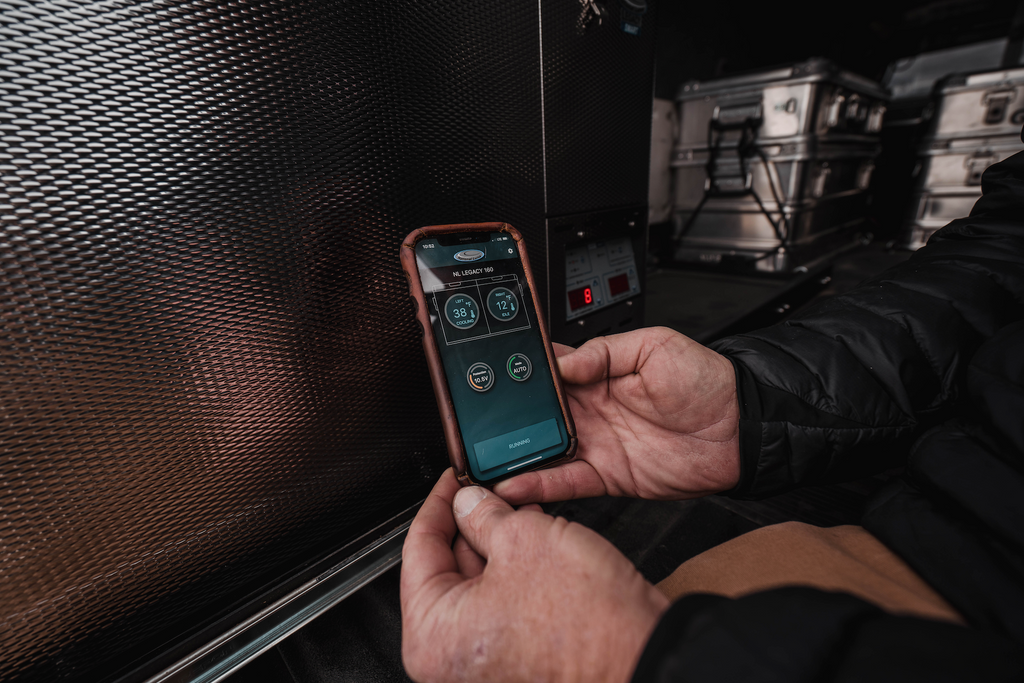 National Luna 35L dual zone fridge freezer, phone showing the NL Connect app held next to the fridge's control panel