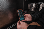National Luna 35L dual zone fridge freezer, phone showing the NL Connect app held next to the fridge's control panel