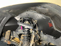 Ark TriXpoly front splash guard with a red logo in a Land Cruiser 200 Series wheel well, behind the coilover