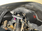 Ark TriXpoly front splash guard with a red logo in a Land Cruiser 200 Series wheel well, behind the coilover