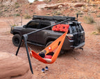 The Outpost stand mounted to a black 4Runner in red desert, an orange hammock slung from it