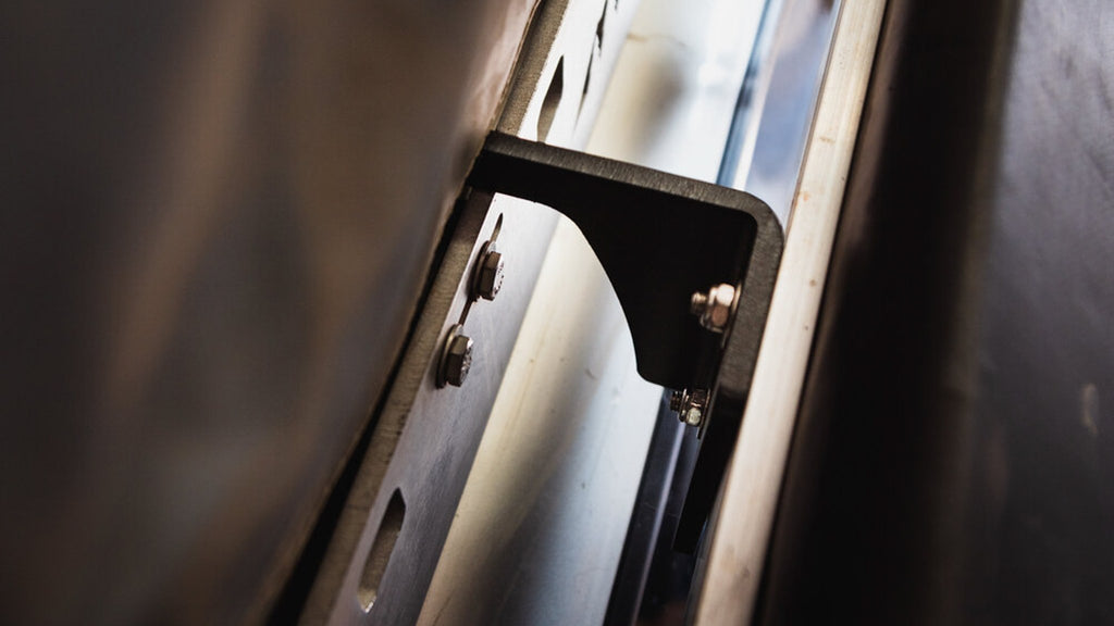Sherpa awning mount bolted between a crossbar and an awning, close-up