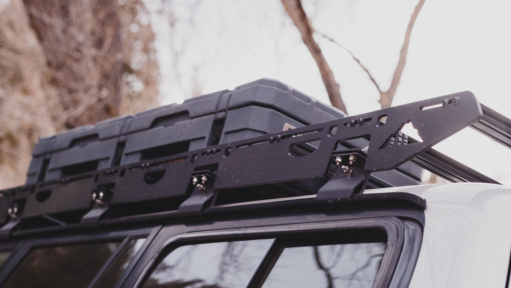 La Sal rack sideplate with cargo cases strapped on an 80 Series roof